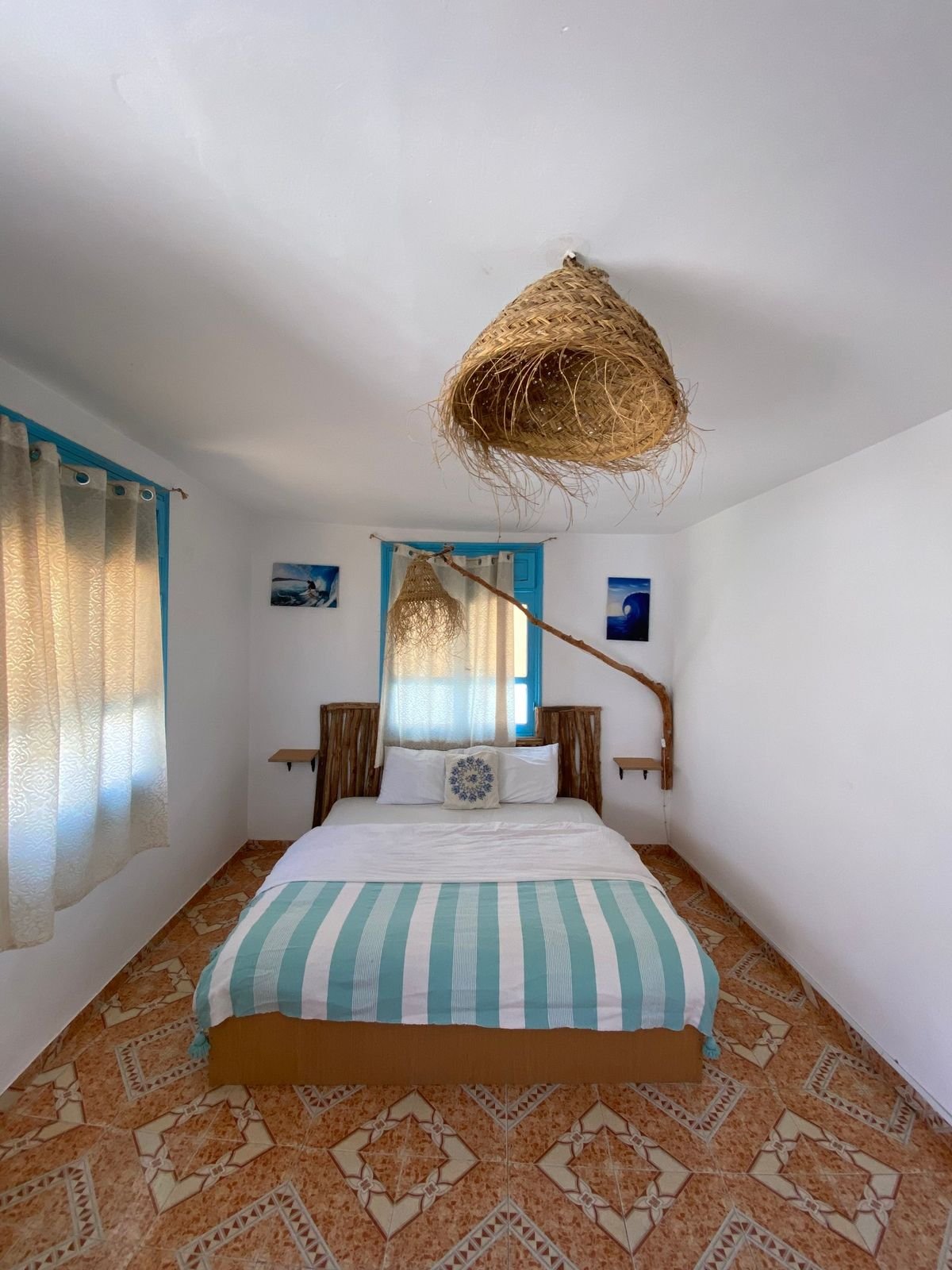 Private double room with a sea-blue striped bedspread at the surf house