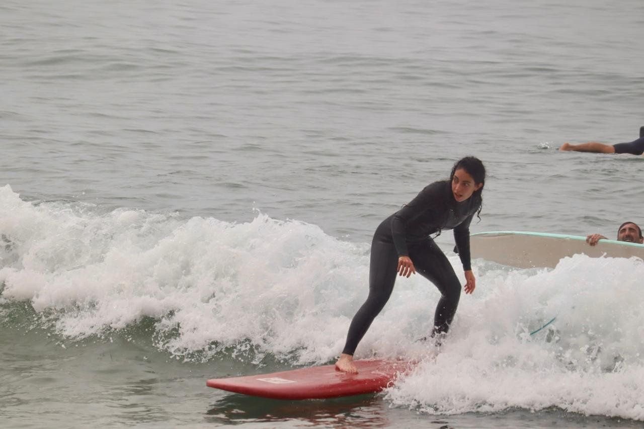 Surfer riding a red board on a small wave