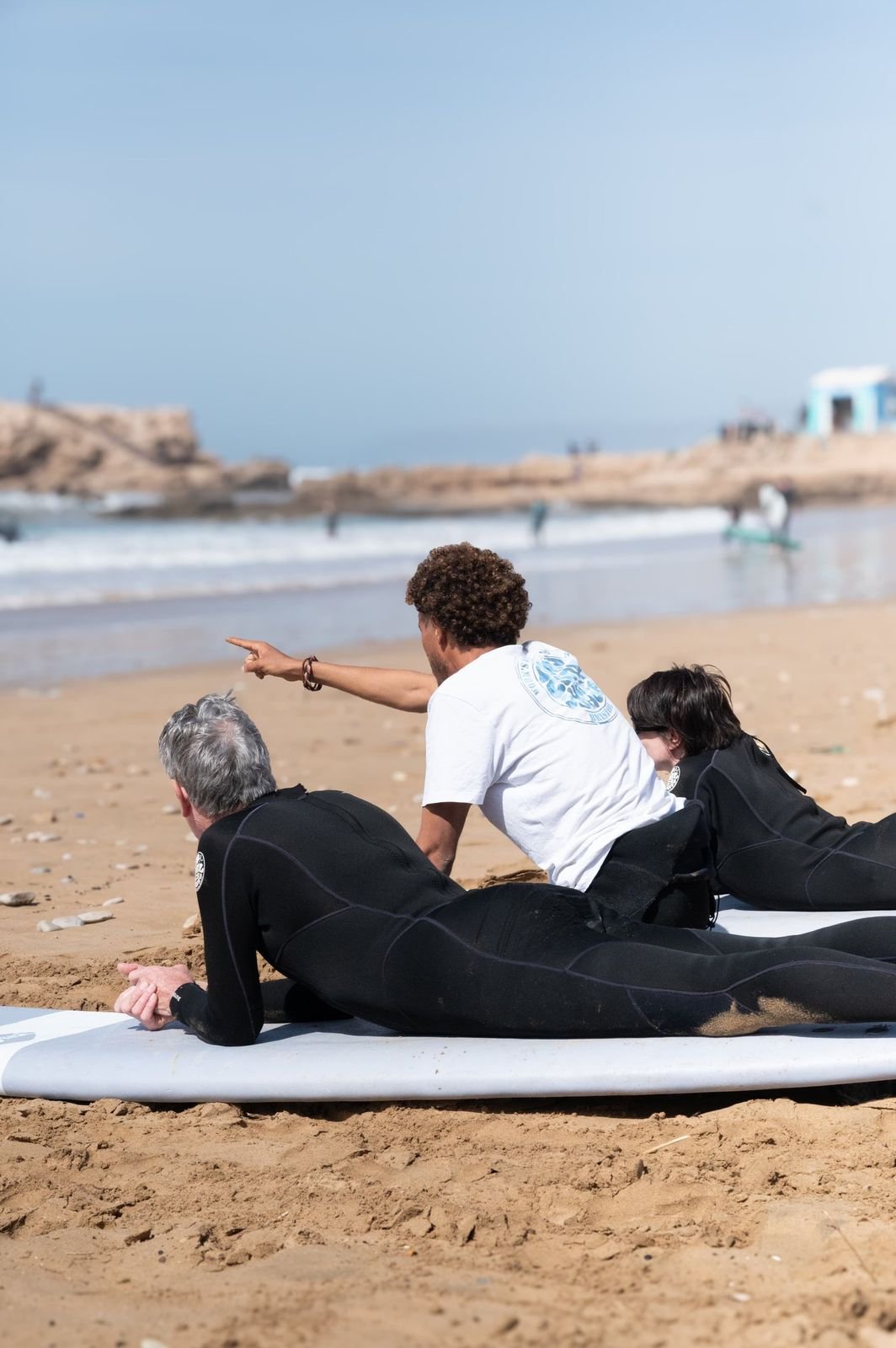 Surf instructor teaching beginners the pop-up on the sand